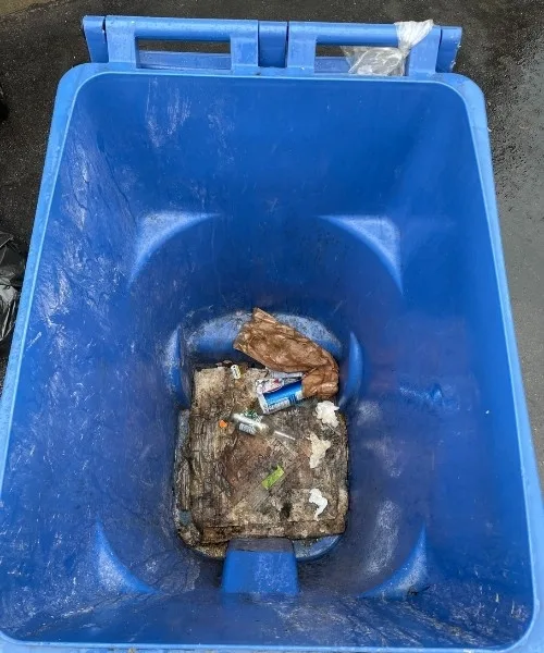 Dirty blue recycling bin before cleaning