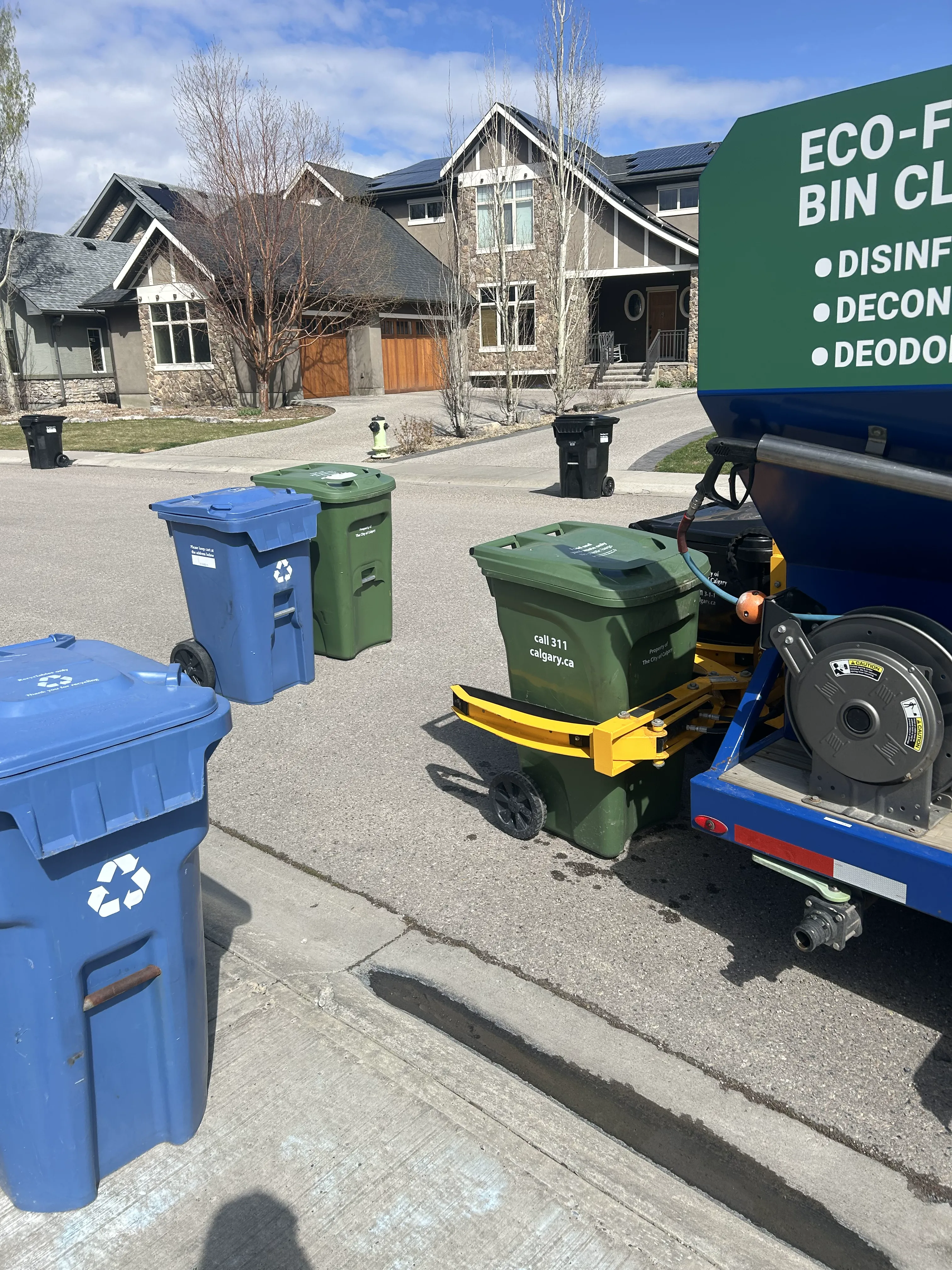 Professional service technician cleaning residential bin