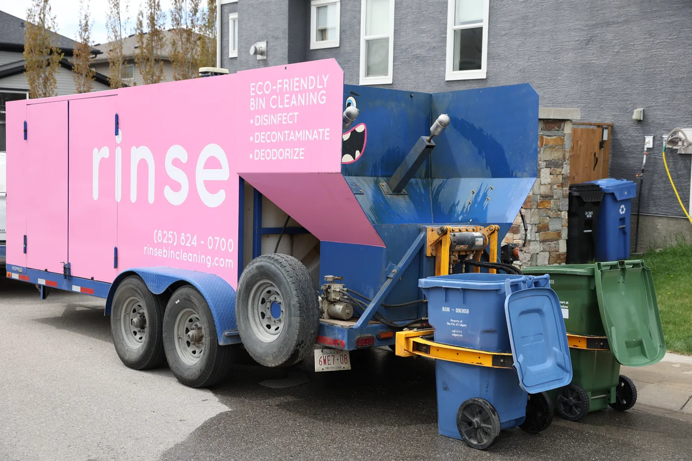 Professional service technician cleaning residential bin